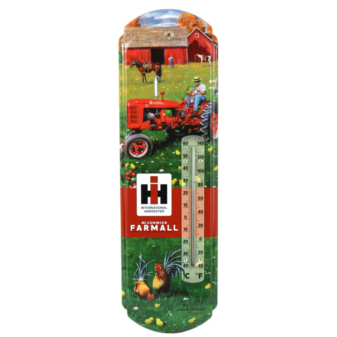 Vintage-style Farmall C Tractor metal thermometer with red tractor, barn, and farm scene, featuring International Harvester logo, 5&quot;x17&quot; in size.